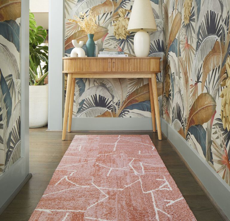Entryway with ornate leaf wallpaper and FLOR Terrain runner rug shown in Coral